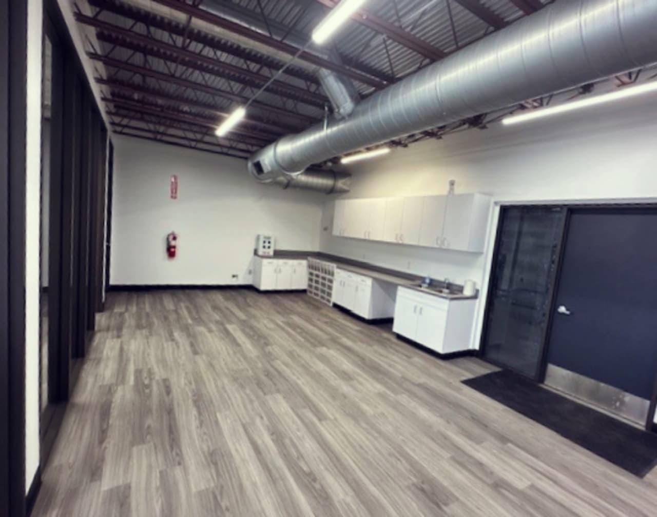 Astrak open workspace with exposed ceiling and pendant lights
